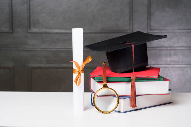 istock Graduation cap with books on white desk , Education background 1267263559