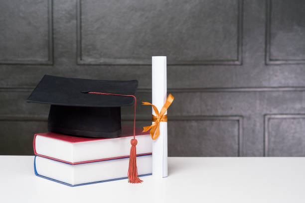 istock Graduation cap with books on white desk , Education background 1267263571