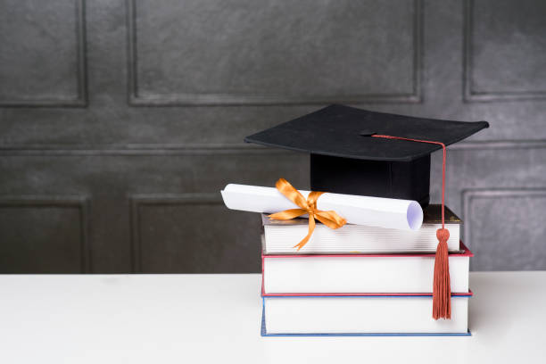 istock Graduation cap with books on white desk , Education background 1267263581