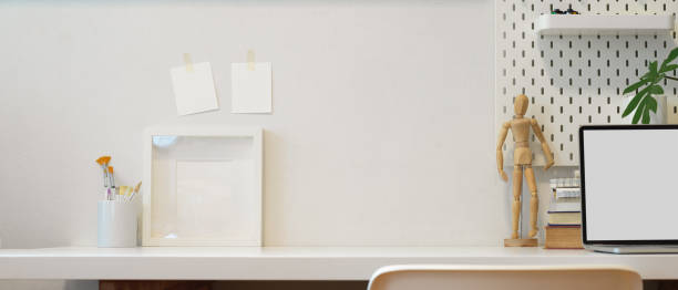 istock Home office desk with copy space, books, mock up laptop, paint brushes and decorations 1267267006