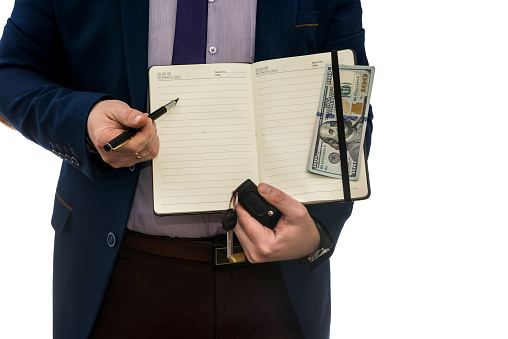 man holding open notebook signs purchase or lease agreement with cash  isolated on white background.