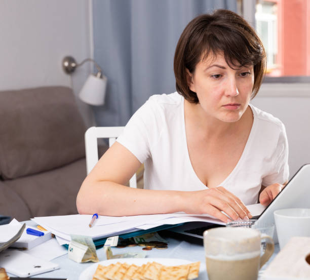 istock Woman with documents while working at laptop at home 1267270641