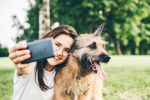 Young attractive girl taking a selfie with her dog