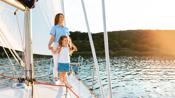 istock Mother And Daughter Posing Holding Hands Standing On Sailboat Deck 1267272136