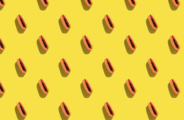 istock Trendy sunlight Summer pattern made with papaya on bright light yellow background. 1267273717
