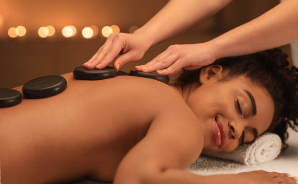 istock Healing hot stone massage for joyful black woman 1267274622