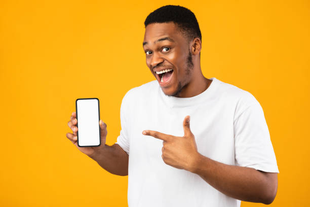 istock African Guy Showing Smartphone Empty Screen Recommending Application, Yellow Background 1267275072