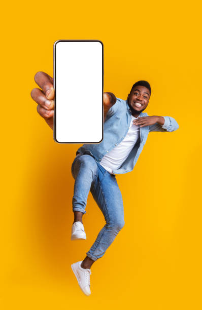 garçon africain excité dansant avec le smartphone moderne - yellow and black photos et images de collection