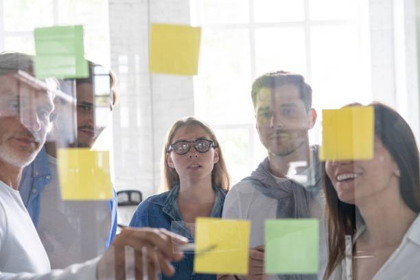 istock Business people meeting at office and use post it notes to share idea. Brainstorming concept. Sticky note on glass wall 1267277959