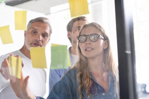 istock Business people meeting at office and use post it notes to share idea. Brainstorming concept. Sticky note on glass wall 1267277967