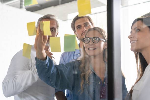 istock Business people meeting at office and use post it notes to share idea. Brainstorming concept. Sticky note on glass wall 1267277968