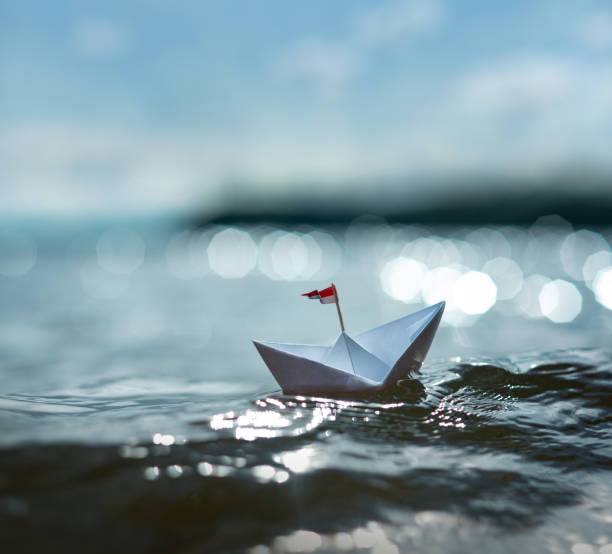 istock nice small paper boat sailing on sunny sea 1267278742