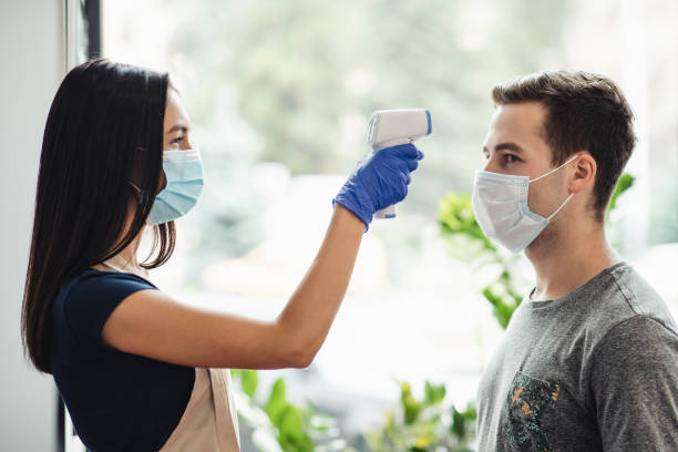 istock Young man getting body temperature screening at barber shop 1267278827
