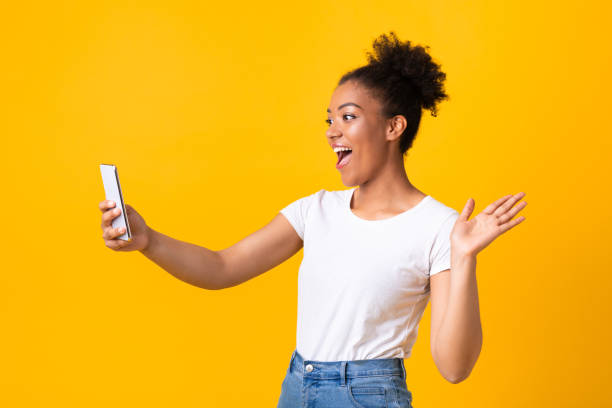 istock Happy girl using mobile phone for video call at studio 1267280151