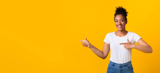 istock Happy afro woman pointing fingers at copy space 1267280174
