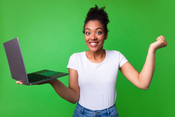 istock Excited afro girl feeling ecstatic holding laptop 1267280447