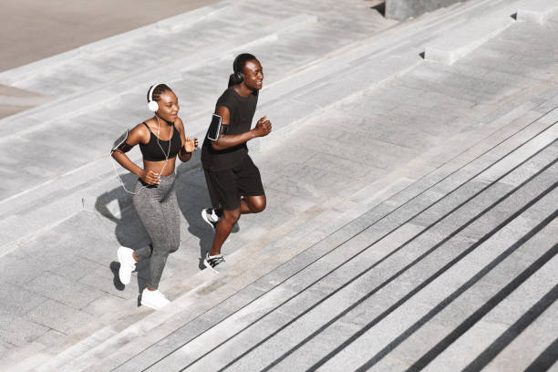 Black Man And Woman Jogging Together In Urban Park, Running Up Steps Black Man And Woman Jogging Together In Urban Park, Running Up Steps, Working Out Outdoors, Empty Space steps exercise stock pictures, royalty-free photos & images