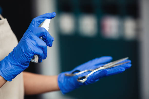 istock Master in medical gloves spraying disinfectant on scissors, close up 1267281442
