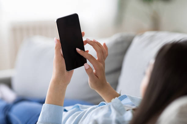 istock Mockup Image Of Unrecognizable Woman Using Smartphone With Black Screen At Home 1267282640