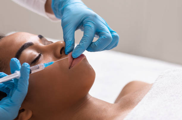 istock African woman pumping her lips, getting filling injection 1267284093