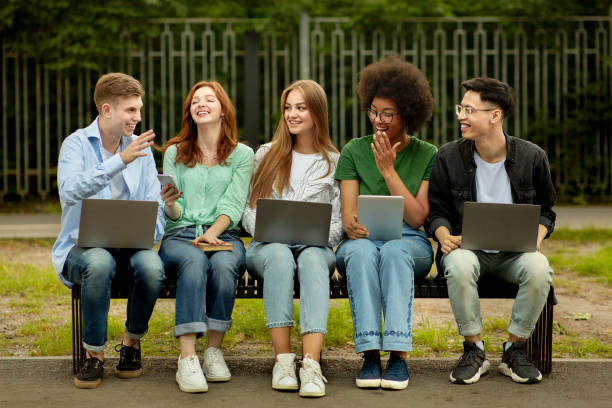 istock Group of college students with laptops and tablet pc studying outdoors 1267284394