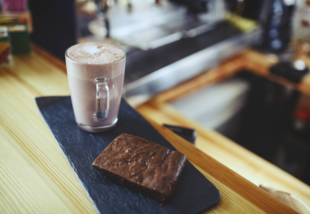 Pink matcha latte with milk in cafe. Tasty drink and brownie cake Pink matcha latte with milk in cafe. Tasty drink and brownie cake. Blurred image, selective focus green tea cocktail bar stock pictures, royalty-free photos & images