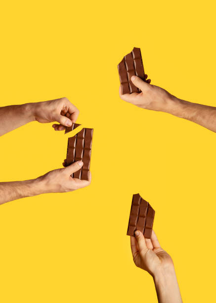 istock Millennial guy holding chocolate bars over orange background, collage 1267286894