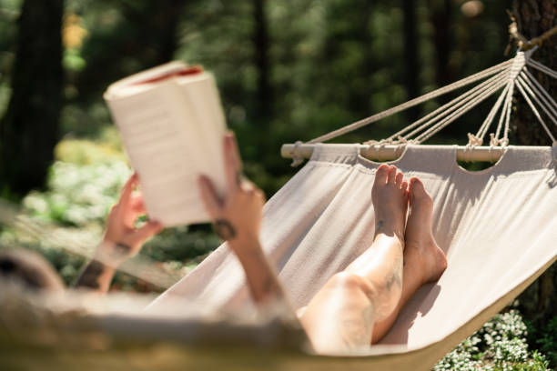 istock Woman in a hammock reading a book 1267287130