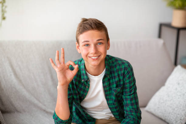 istock Cheerful teenager guy showing okay gesture, posing on camera 1267289412