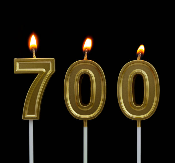 istock Birthday golden candle on black background, number 700 1267292621