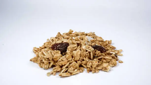 Photo of Close up shot of a Heap of healthy granola cereal on white background