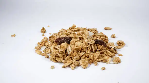 Photo of Close up shot of a Heap of healthy granola cereal on white background
