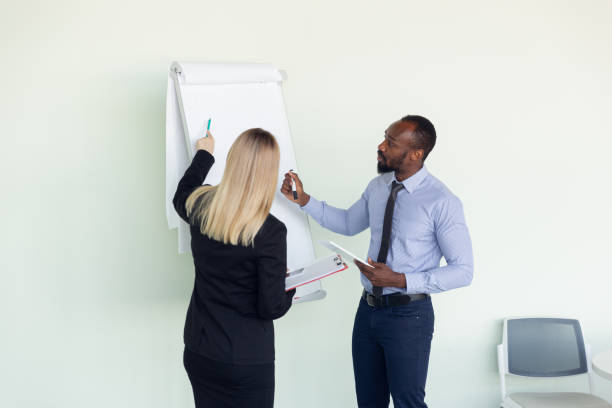 istock Young businessman working with colleague using flipchart, copyspace 1267293244