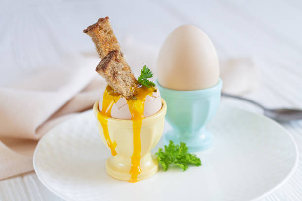 istock Boiled eggs in eggcups with spices, herbs and toasted bread for breakfast 1267294642