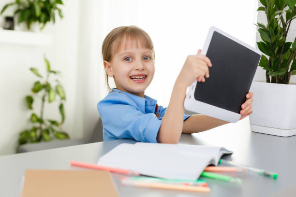 istock Remote lessons. The child smiles happily and gets knowledge remotely. Little girl study online learning from home. Online school. 1267294784