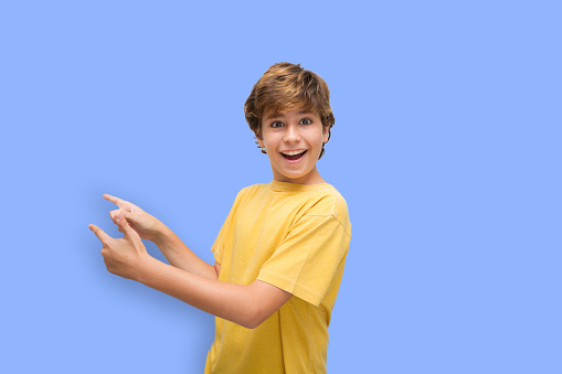 Handsome Spanish boy. Selection of expressive gestures with humor. pointing to the side with both hands smiling happily