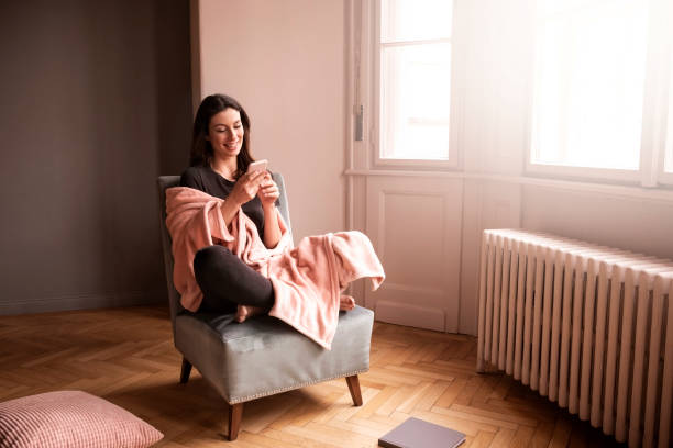 istock Happy woman text messaging while relaxing at home 1267298972