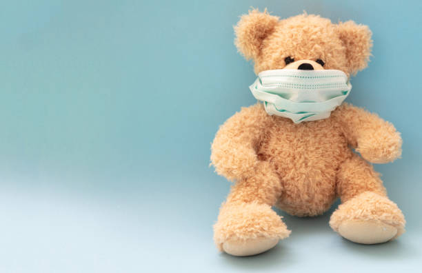 istock Coronavirus and pollution protection concept. Teddy bear with protective face mask on blue background 1267300110