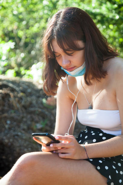 istock Young woman with mobile and mask 1267301056