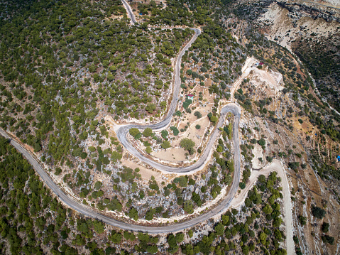 A winding mountain serpentine asphalt road. Top down aerial view.
