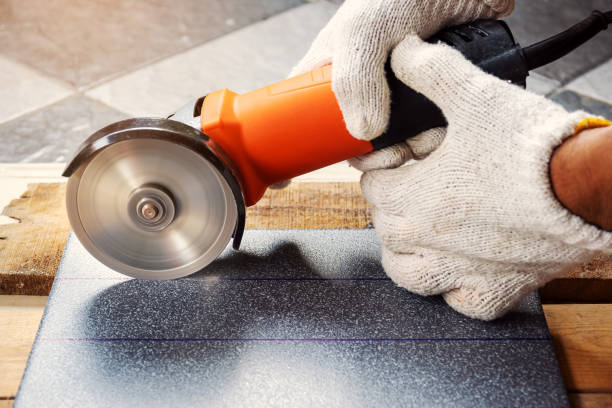 Cut the tiles with an electric grinder. Construction worker wearing white cloth gloves was cutting the tiles with an electric grinder. grinder stock pictures, royalty-free photos & images