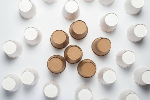 istock White and brown paper cups flipped upside down on a light background. Top view, flat lay 1267305945