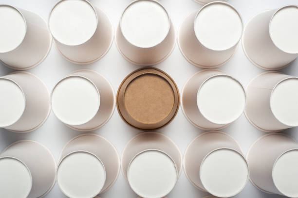 istock Many white and one brown paper cups, flipped upside down on a light backgroundon a light background. Top view, flat lay. 1267306159
