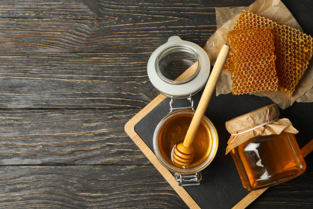 istock Composition with honeycombs, honey, jars and dipper on wooden background 1267306848