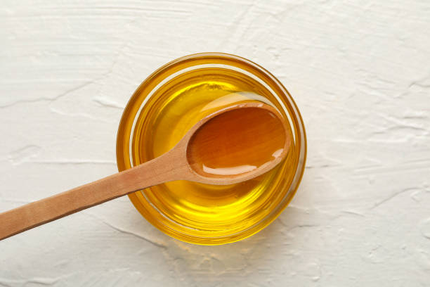 istock Bowl with honey and spoon on white background, top view 1267306943