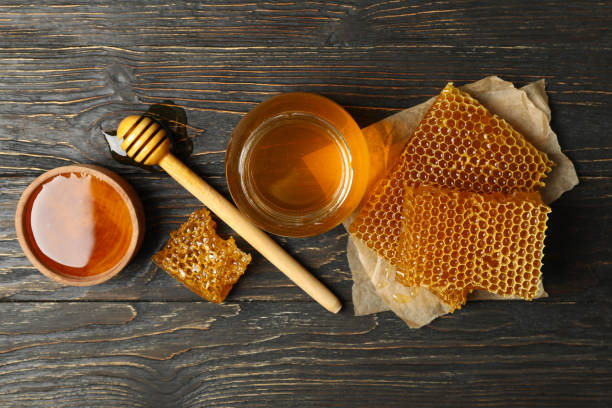 istock Honeycombs, jar with honey and dipper on wooden background 1267307948