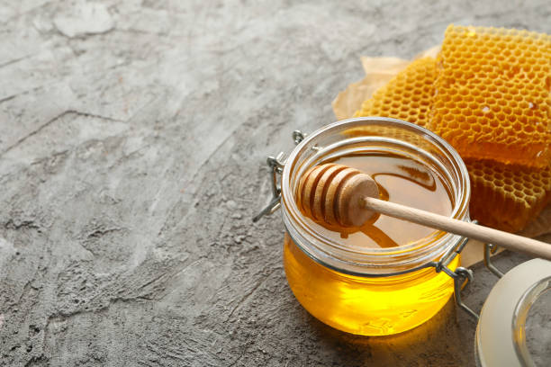istock Composition with honeycombs, honey and dipper on gray background 1267308384