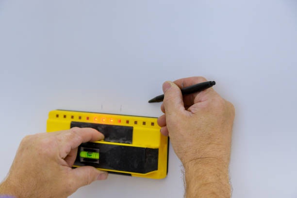 istock Man hand is scanning wall by finding wooden beams to wall 1267309125