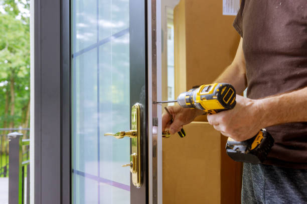 istock Install the door handle with a lock, Carpenter tighten the screw, using an electric drill screwdriver, 1267309141