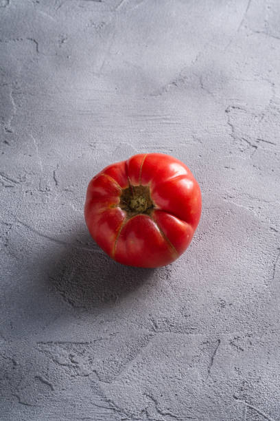 un vegetal de tomate de reliquia rosa, tomates rojos frescos maduros, comida vegana, fondo de hormigón de piedra, vista angular - tomato beefsteak tomato heirloom tomato pink fotografías e imágenes de stock